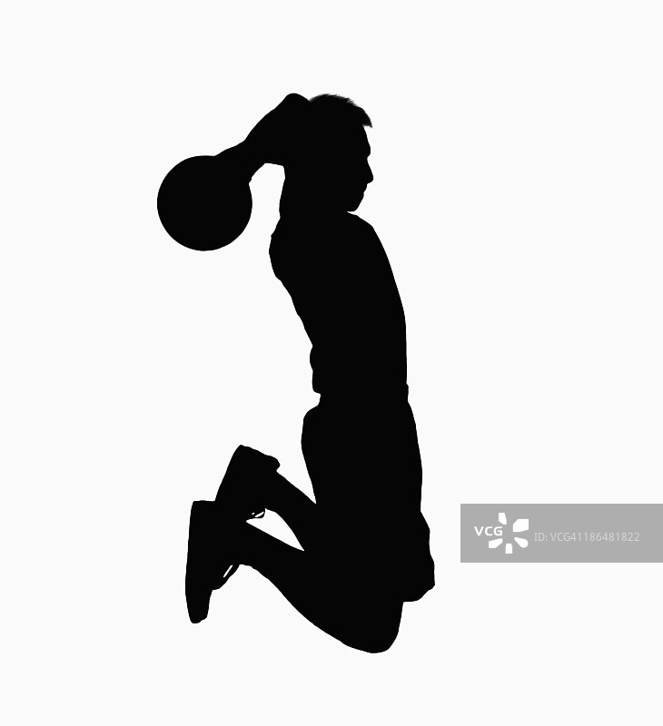 篮球运动员带着球跳的剪影。图片素材