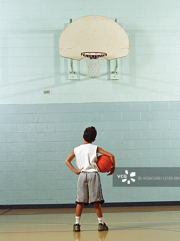 男孩(8-10)拿着篮球，看着篮筐，后视镜图片素材