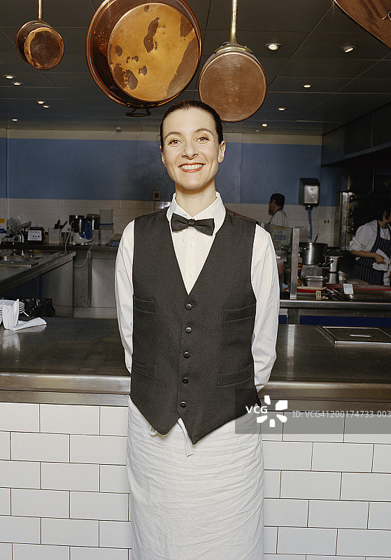 女服务员站在厨房，微笑着，画像图片素材