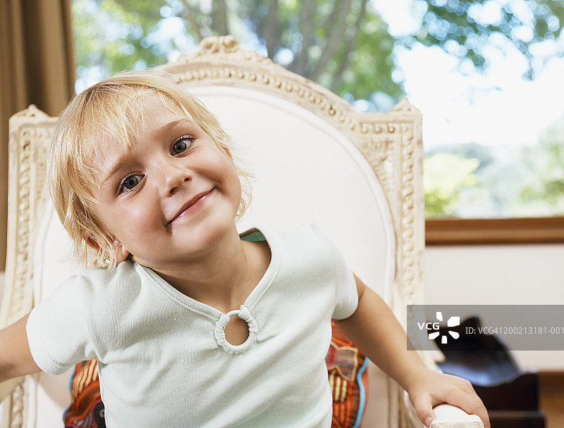 女孩(4-6岁)坐在高靠背上，面带微笑，肖像图片素材