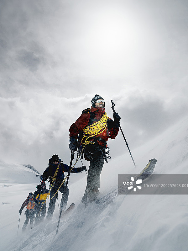 在暴风雪中行走的登山者，用绳子连在一起图片素材