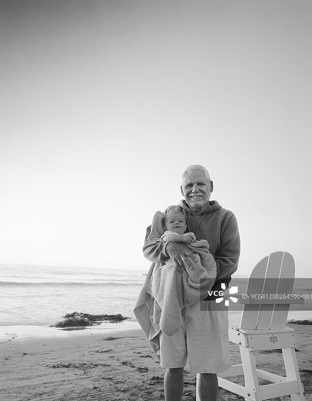 老人抱着小孙子(3-5个月)在海滩上，人像(黑白)图片素材