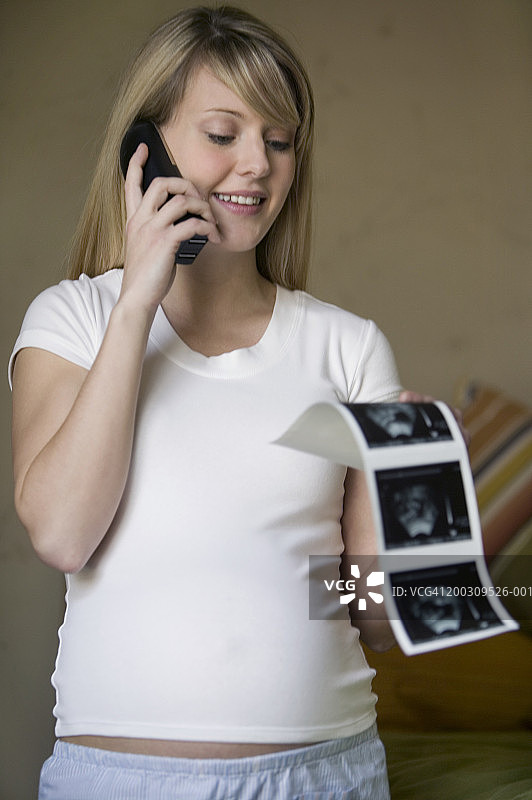 孕妇使用手机，手持超声波打印，室内图片素材
