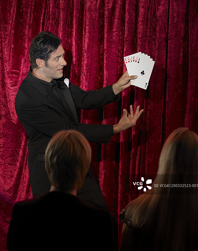 男人在舞台上表演纸牌戏法图片素材