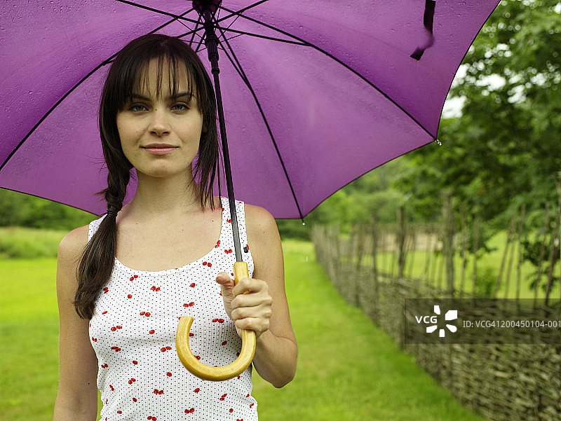年轻女子拿着紫色伞，画像图片素材