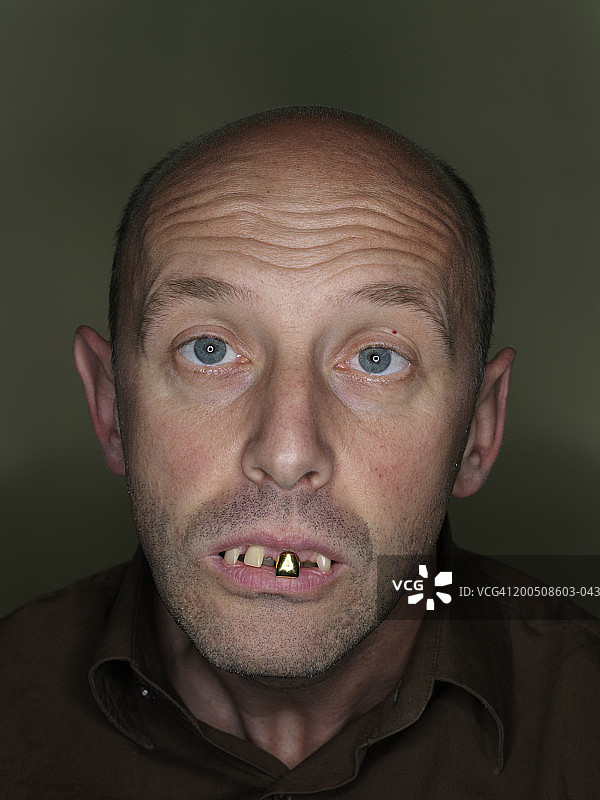 成熟的男人戴着假牙，做鬼脸，特写，肖像图片素材