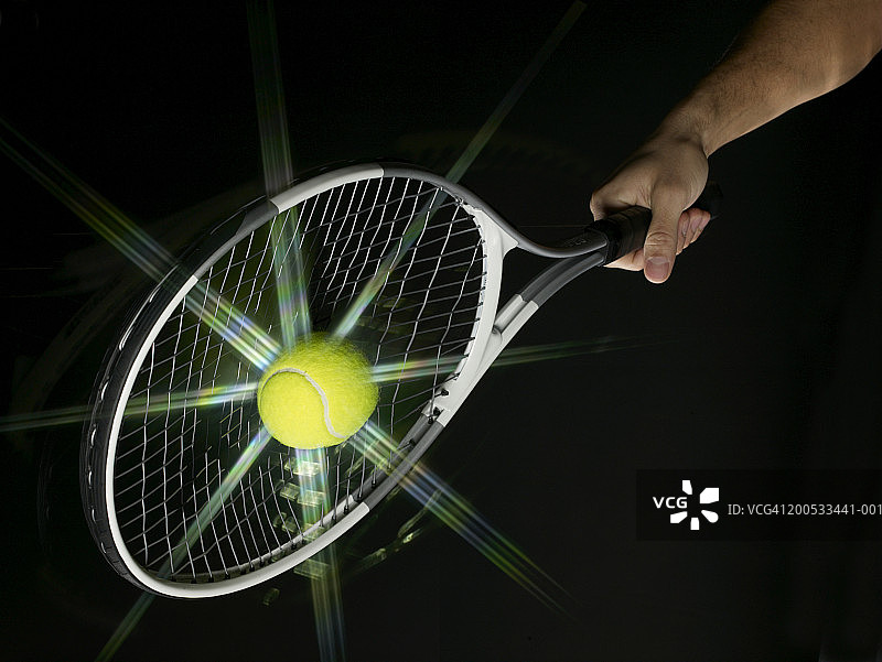 年轻人用球拍打网球，(数码合成)图片素材