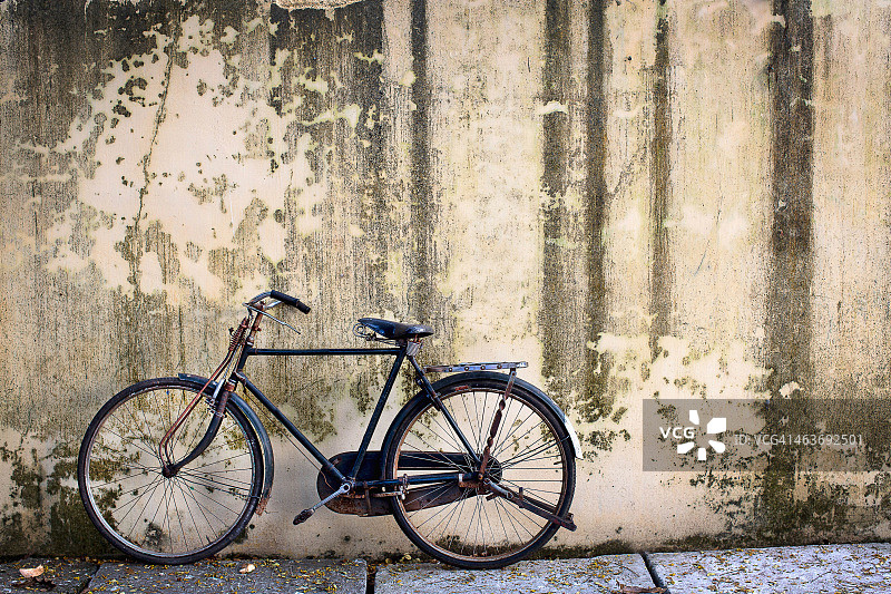 靠着土墙的旧自行车图片素材
