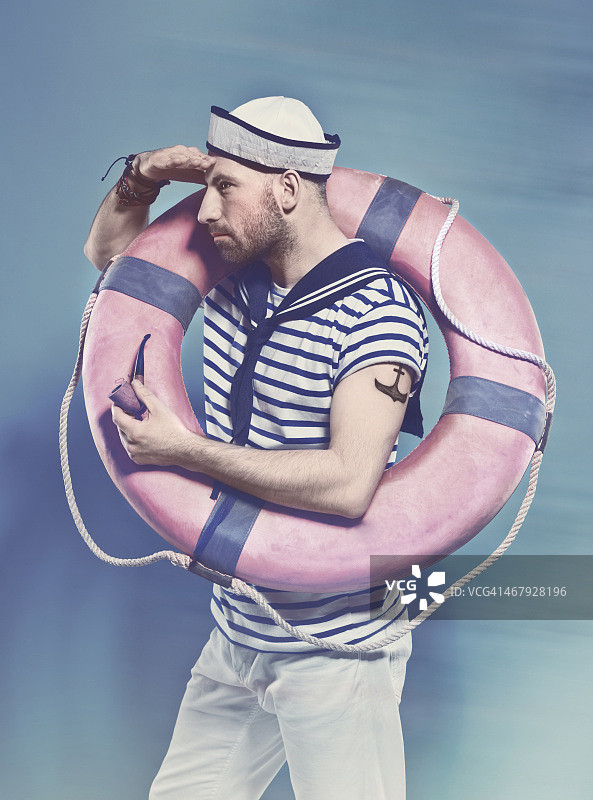 蓄着胡子的男子在水手风格的服装拿着救生圈图片素材