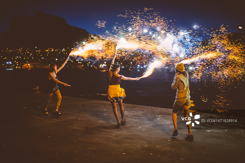 年轻的垃圾摇滚女孩在晚上与烟花跳舞图片素材