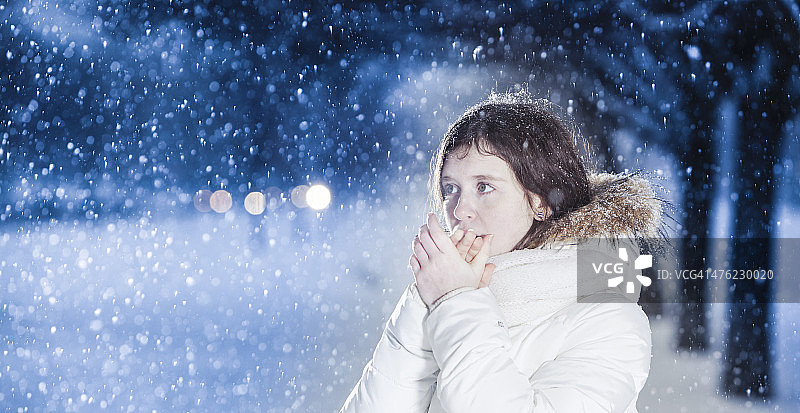 雪下穿着白色夹克的漂亮少女图片素材