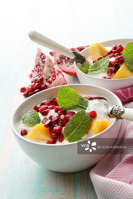 甜点:酸奶配芒果，石榴和薄荷静物图片素材