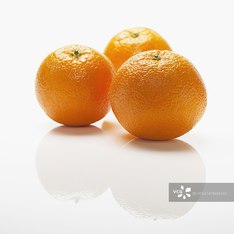 三个成熟的橙子配上白色的背景图片素材