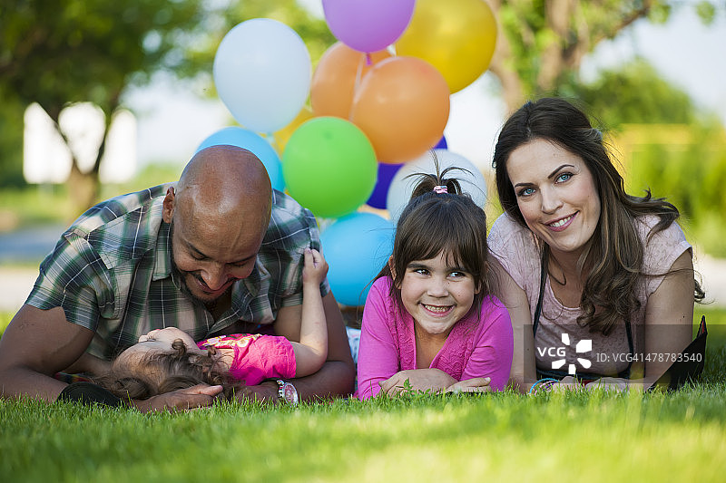 美丽的一家人在野餐时玩气球图片素材