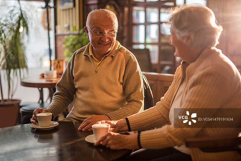 快乐的老夫妇享受在咖啡馆和交流。图片素材
