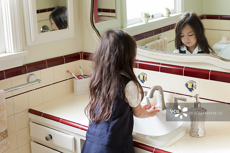 小女孩在她家的浴室里洗手图片素材