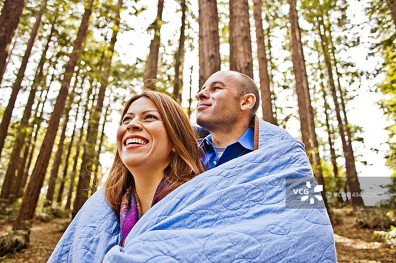 一对西班牙夫妇裹着毯子在森林里图片素材