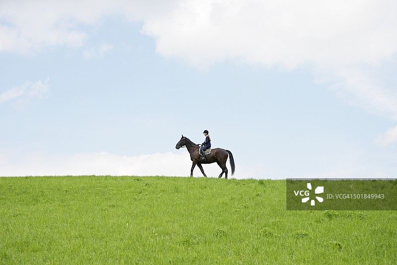 在德国巴登符腾堡的乡村风景中骑马的女人图片素材