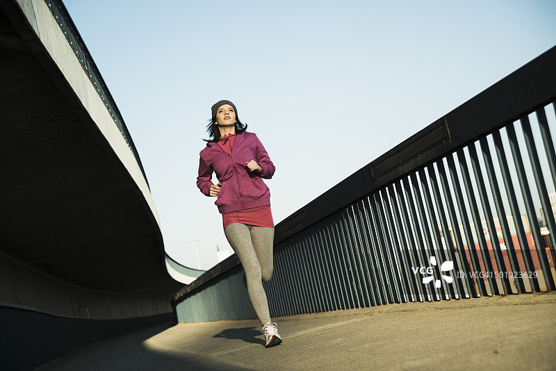 年轻女性在桥上慢跑图片素材