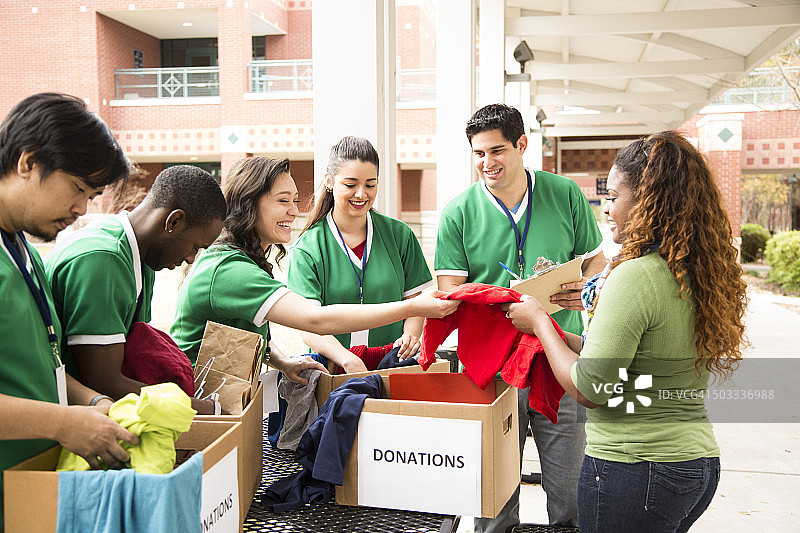大学生志愿者小组收集衣物捐赠。慈善机构。图片素材