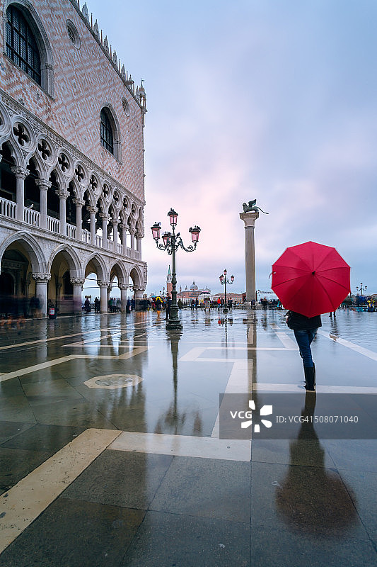 威尼斯圣马可广场，一名女子撑着雨伞被洪水淹没图片素材