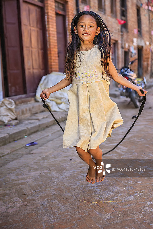 年轻的尼泊尔女孩玩跳绳图片素材
