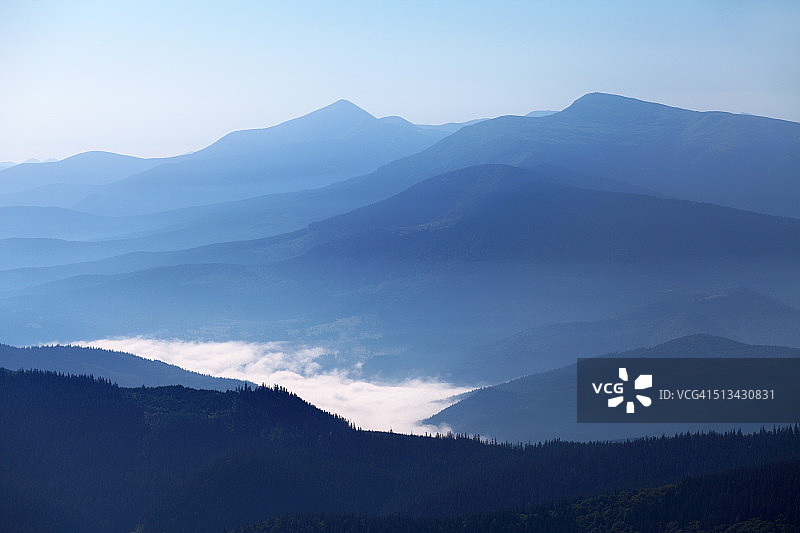 群山的顶峰笼罩着蓝色的薄雾图片素材