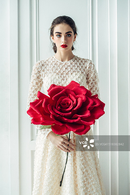工作室拍摄的年轻美丽的新娘与大玫瑰图片素材