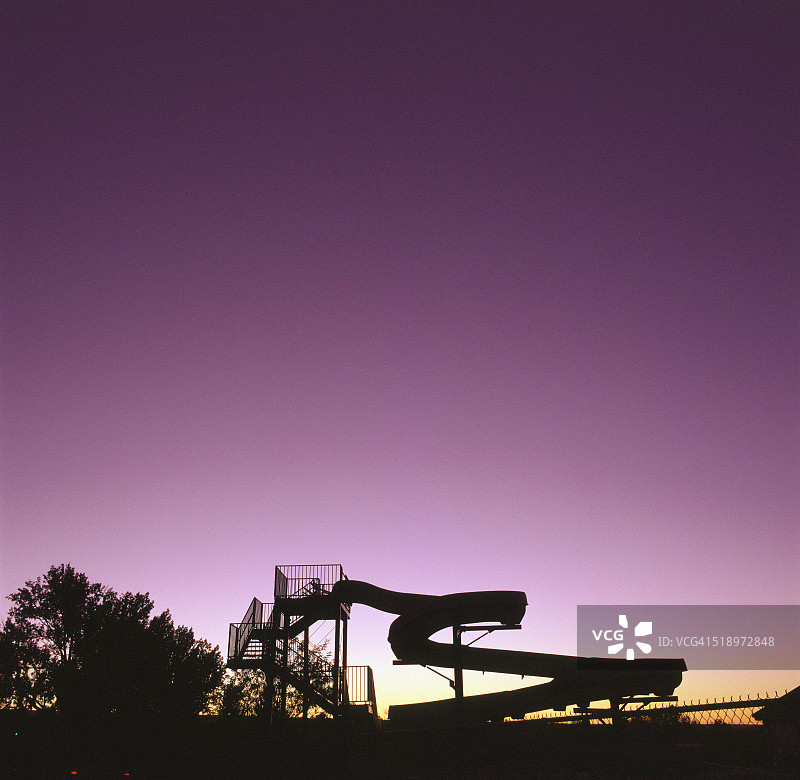 紫色天空下蜿蜒的滑水道的剪影图片素材