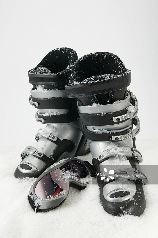 雪地里一双滑雪靴和一副滑雪镜的细节视图图片素材
