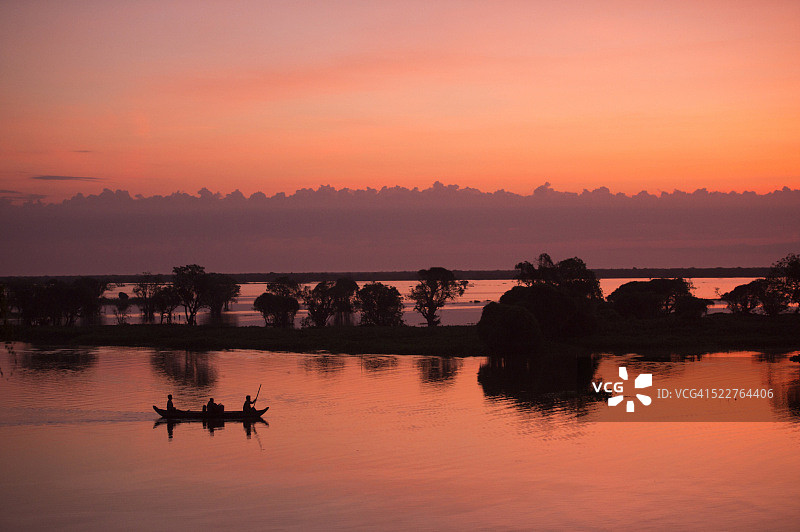 洞里萨湖的日出天空和渔夫在船上钓鱼图片素材