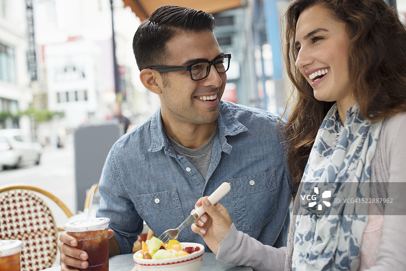 微笑的夫妇在街边的餐馆用餐图片素材