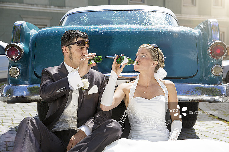 新婚夫妇在老爷车前喝着短笛图片素材