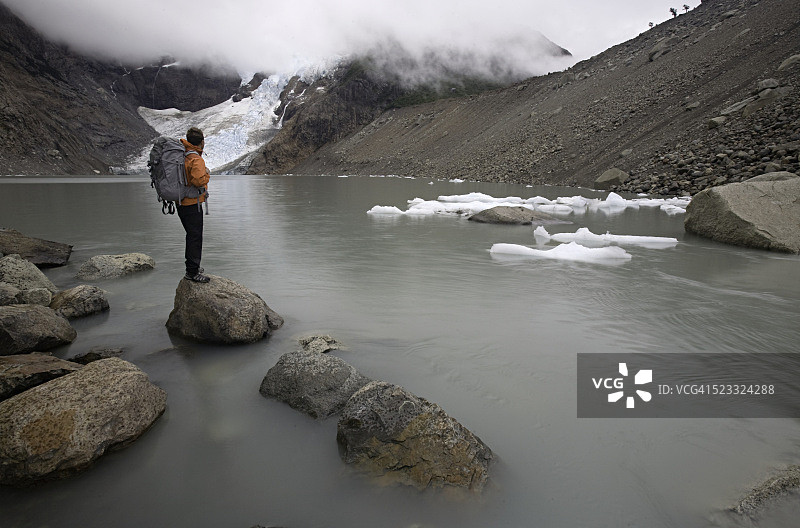 一个登山者站在湖中的岩石上图片素材