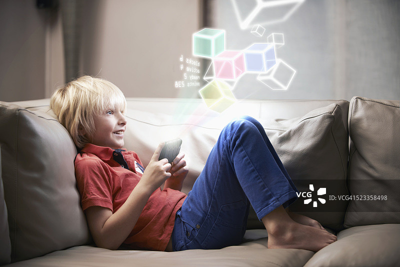 男孩(6-7)在未来设备上玩游戏图片素材