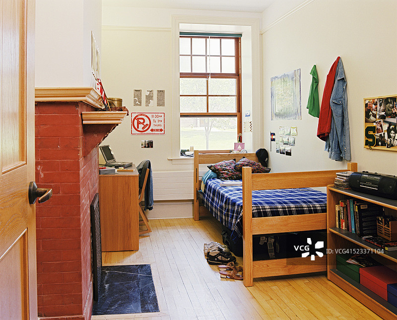 带有砖砌壁炉和木地板的宿舍房间图片素材