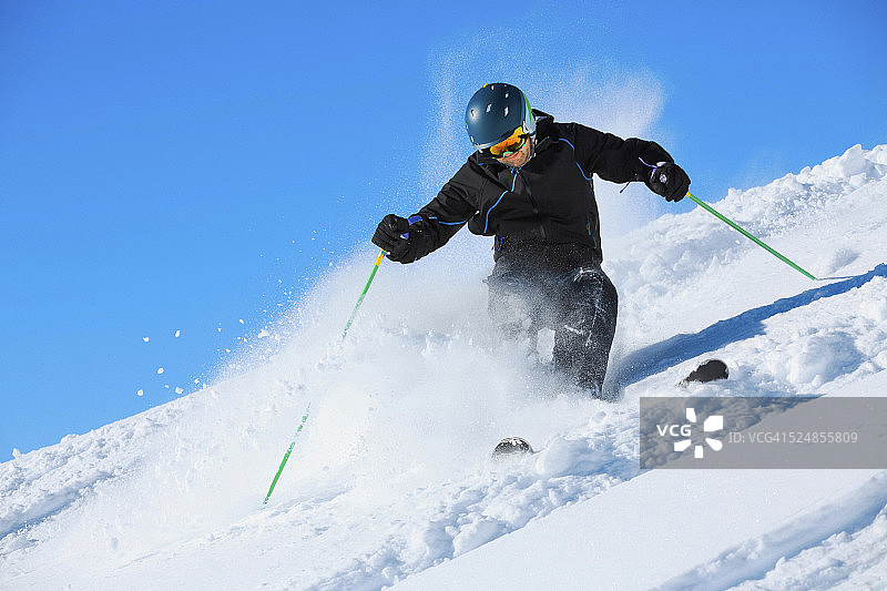 成熟的男人在雪道外滑雪粉雪阳光明媚的滑雪场图片素材