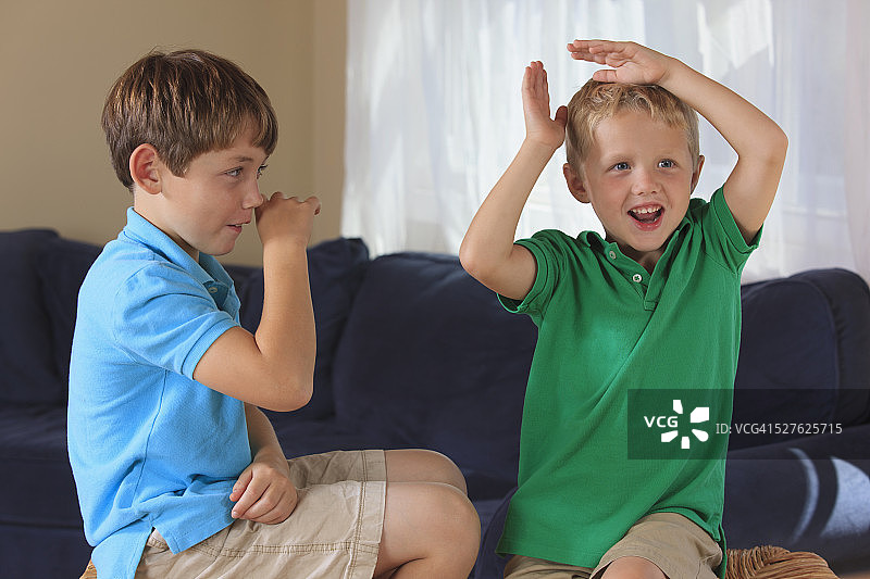 有听力障碍的男孩在沙发上用美国手语手语图片素材