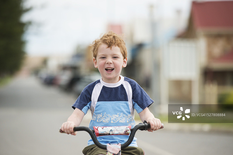 年轻的男孩骑自行车在公路上，澳大利亚图片素材