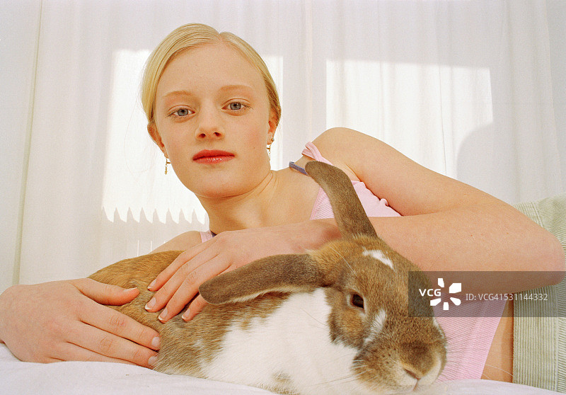 少女和兔子躺在床上图片素材