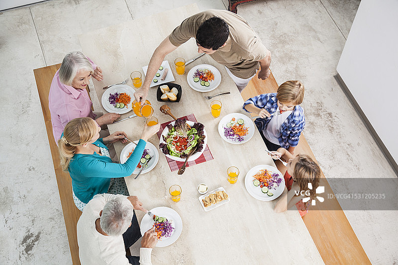在餐桌上享用沙拉和果汁的大家庭图片素材