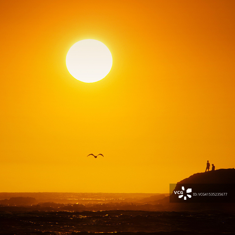 拉古纳海滩的金色日落剪影图片素材