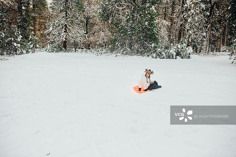 在约塞米蒂国家公园的雪地里坐雪橇的女孩图片素材