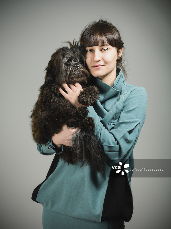 一个快乐的年轻女人和她的狗的肖像图片素材