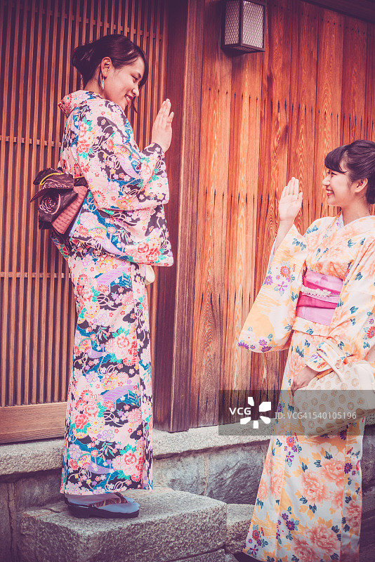 美丽的日本主人穿着和服迎接她的朋友，京都，日本图片素材
