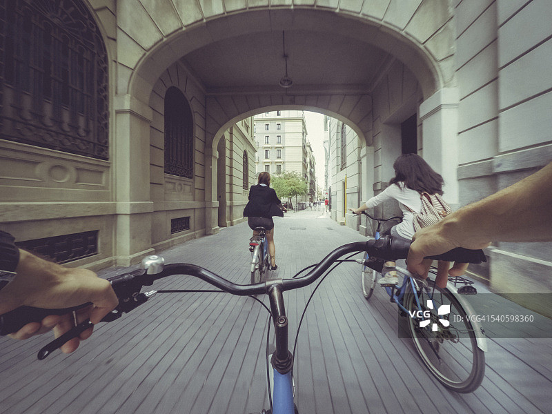 POV和两个女孩在城市里骑自行车图片素材