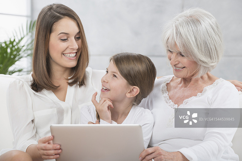 祖母，母亲和女儿使用笔记本电脑图片素材