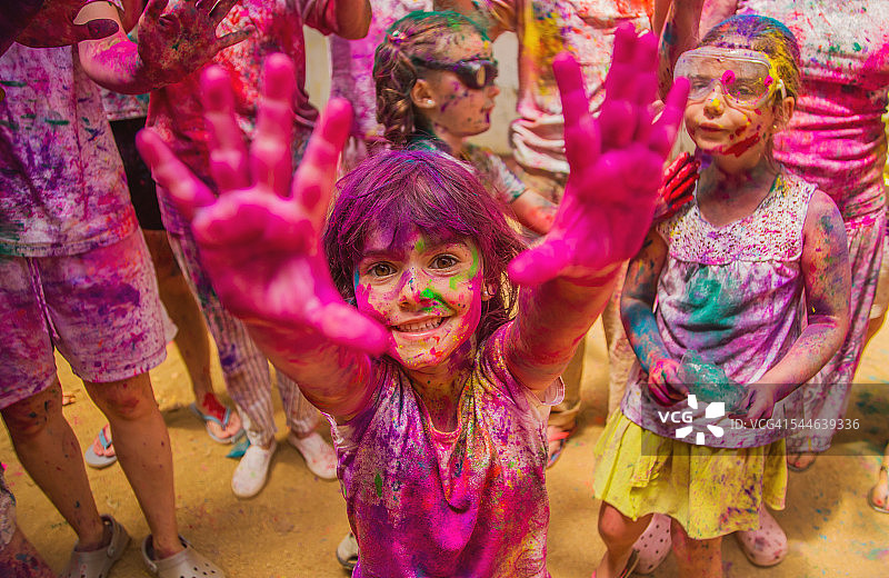 人们聚集在一起，在户外庆祝一个胡里节派对，幸福的表情和覆盖着生动的颜色。图片素材