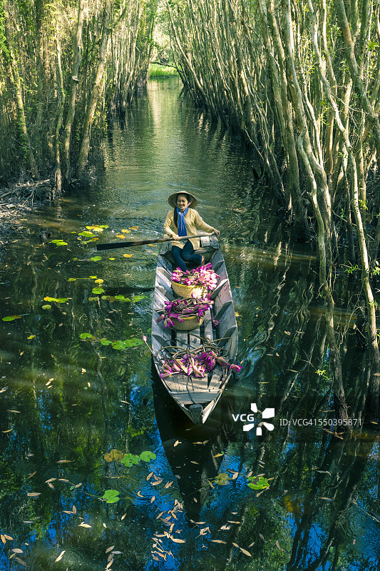 年轻的越南女子划船载着鲜花图片素材
