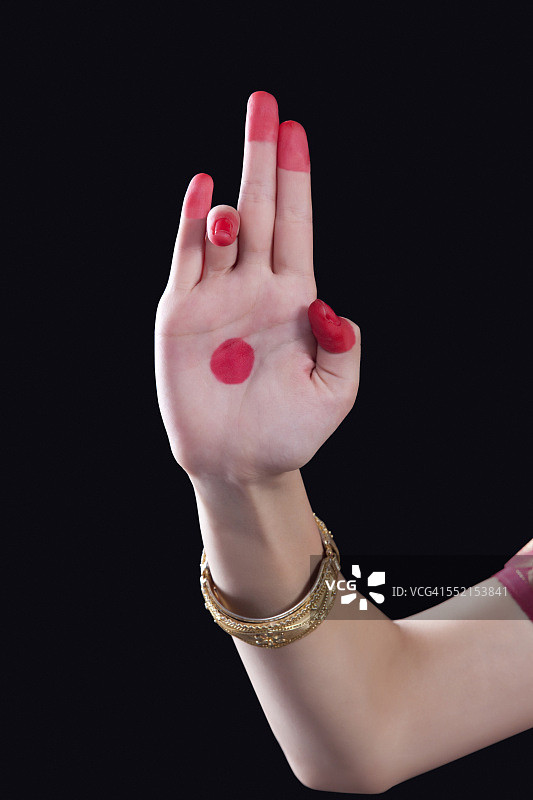 一个女人的手在黑色的背景上做了一个叫做Tripataka的Bharatanatyam手势图片素材